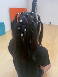 切る前に頭髪をいくつかに分けてしばるブロッキングを行います（細野晃司さん提供）