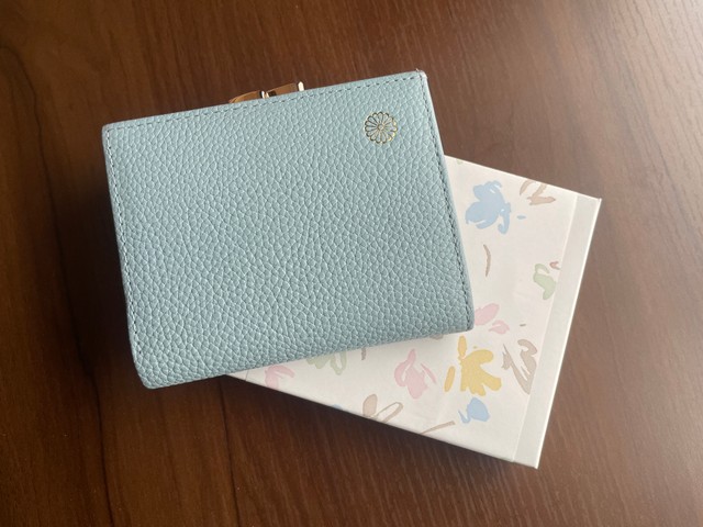 コロさんが2025年夏、本丸休憩所で購入したがま口財布。購入時に財布が入っていた白い箱とともに（提供画像）