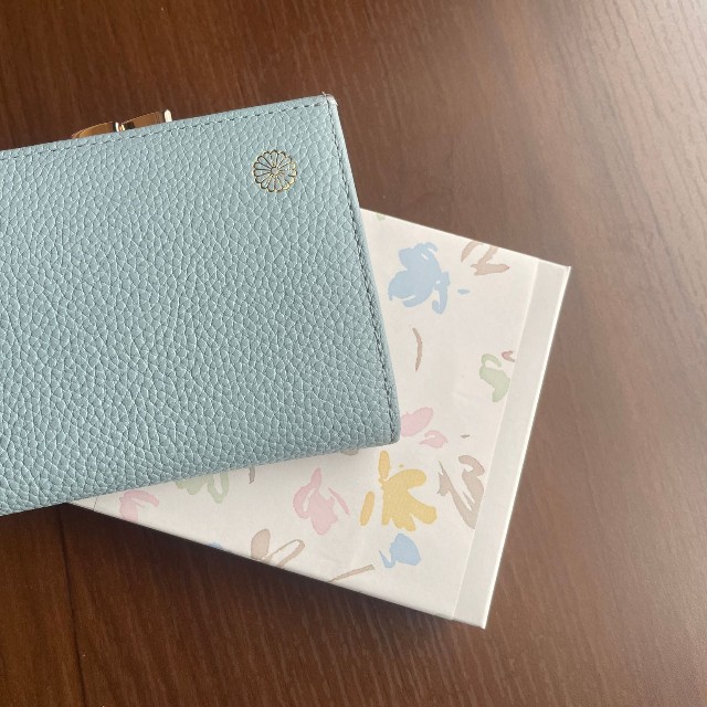 コロさんが2025年夏、本丸休憩所で購入したがま口財布。購入時に財布が入っていた白い箱とともに（提供画像）