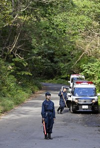 全国各地でクマの人身被害が相次ぐ中、クマに襲われた可能性がある遺体が見つかった山林付近で警戒する警察官＝2025年10月８日午後、岩手県北上市（提供・共同通信社）