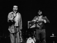 ライブに飛び入りでステージに上がった渥美清さん（左）に激励される佐藤蛾次郎さん（提供・佐藤蛾次郎さん）