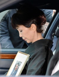 愛川欽也さんの遺影を持ち自宅を出るうつみ宮土理さん=2015年