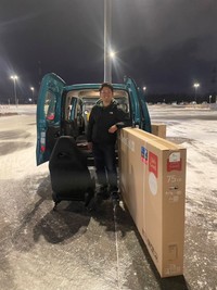 車に入らないテレビとともに満面の笑みで写真に写るさかいさん。 ※さかいとしたかさん提供