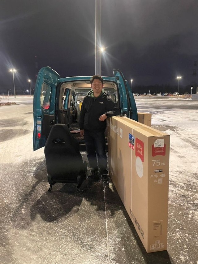 車に入らないテレビとともに満面の笑みで写真に写るさかいさん。 ※さかいとしたかさん提供