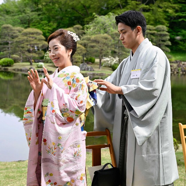 春の園遊会で三浦璃来選手（左）の帯を直す五輪フィギュアスケート・ペアの木原龍一選手=2026年4月17日