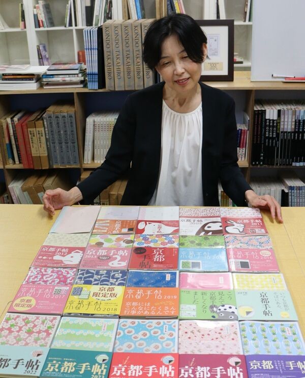 ２００７年版から刊行してきた歴代の「京都手帖」を見つめる大西律子編集長（京都市中京区・光村推古書院）