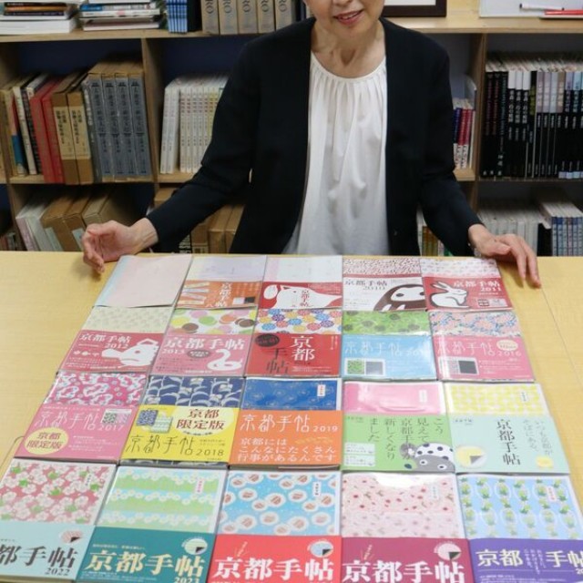 ２００７年版から刊行してきた歴代の「京都手帖」を見つめる大西律子編集長（京都市中京区・光村推古書院）