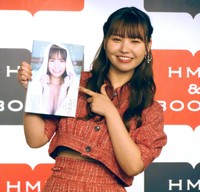 写真集を手に笑顔を見せる本郷柚巴＝2023年