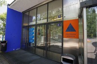 ヘルシンキ市イタケスクスの市民プールの地上入り口。オレンジ地に青い三角形の標識はシェルターがあることを示している＝2023年5月30日、荒ちひろ撮影