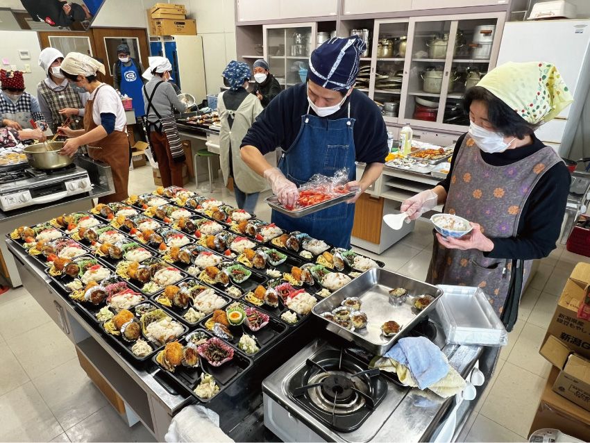 おかずを詰めるボランティアたち＝新潟県阿賀町の阿賀町社会福祉協議会