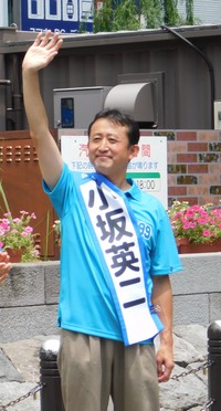 聴衆に手を振る小坂英二氏