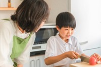 冷やし中華にのせるトマトを切る小学生　※画像はイメージです（buritora@stock.adobe.com）一部トリミングしています