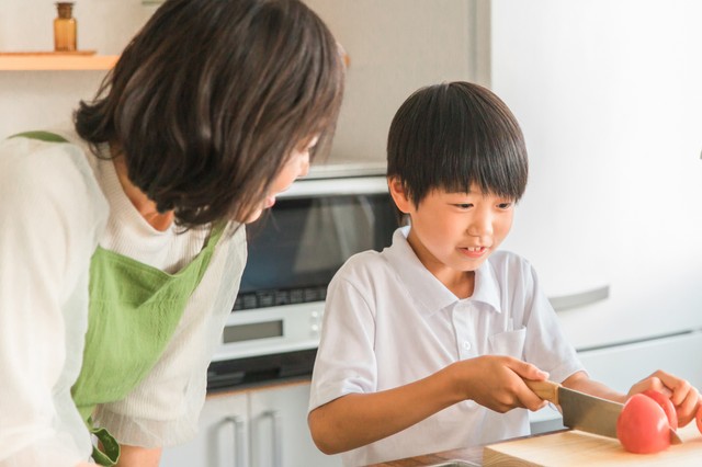 冷やし中華にのせるトマトを切る小学生　※画像はイメージです（buritora@stock.adobe.com）一部トリミングしています