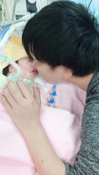 入院中、家族は我が子の足を軽く持ち上げて筋肉に刺激を与えていた