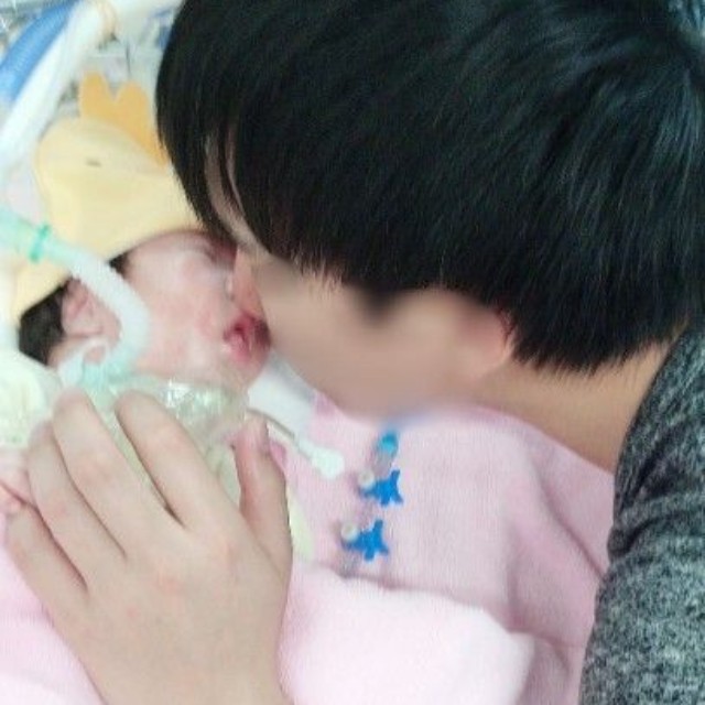 入院中、家族は我が子の足を軽く持ち上げて筋肉に刺激を与えていた