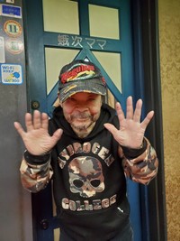 「さようなら」。閉店した自身の店「蛾次ママ」の扉前で手を振った佐藤蛾次郎さん＝東京・銀座（２０２０年撮影）