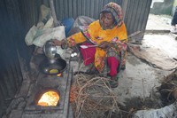 家の外にある台所で、枝を燃やして調理するモモタジュ・ベグンさん=2024年5月6日、ダッカ近郊、荒ちひろ撮影