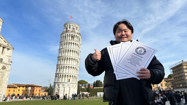 ピサの斜塔前でギネス記録書をひけらかすウエスＰ