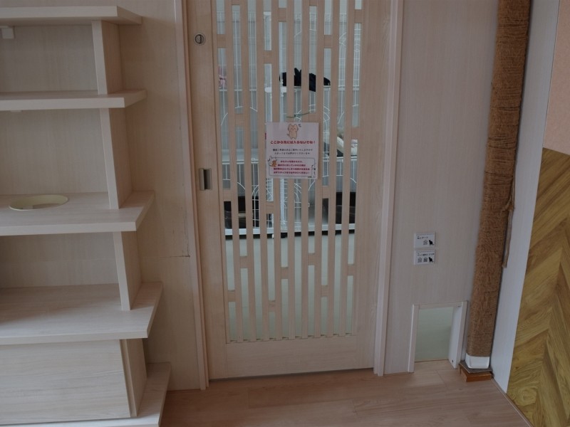 「保護ねこカフェもりねこ」の一角にあるドア。お客さんはこのドアの向こうには行けないが、猫は右下の小さな入り口から自由に出入り出来る