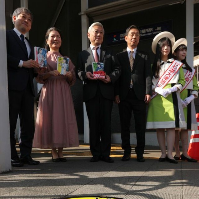作者の宮島未奈さん（左から２人目）らが立ち合い、京阪膳所駅の近くに設置された主人公成瀬あかりを描いたマンホールのふた＝１９日、大津市馬場２丁目
