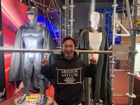 「『ブラックアダム』公開記念 “DCユニバースの世界”」会場で、バットマン（左奥）などの展示物に囲まれてご機嫌のなべやかん＝都内の日テレホール