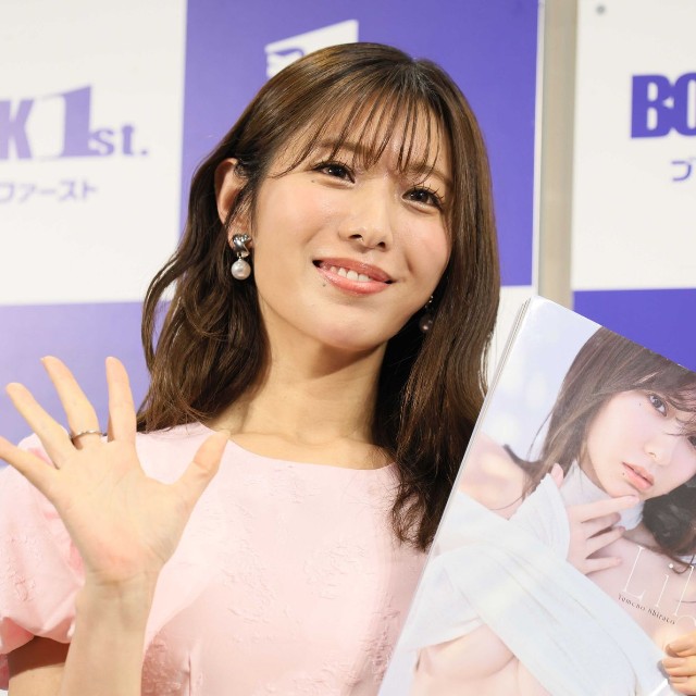 写真集を手にポーズをとる白戸ゆめのさん