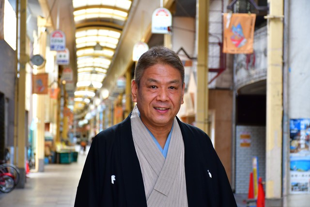 安立商店街に立つ遊喬さん