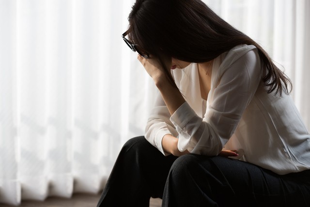 頭を抱え悩んでいる女性※画像はイメージです（kei907/stock.adobe.com）
