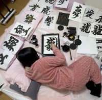 工夫を重ねて導きだした体勢で書を書く星野さん（提供：星野希望さん）
