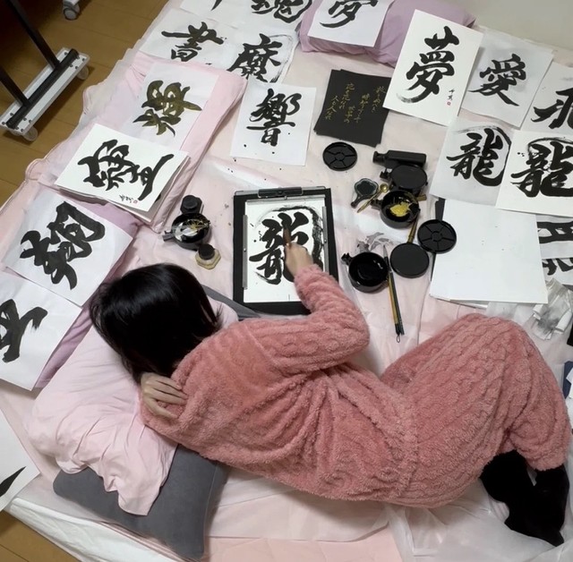 工夫を重ねて導きだした体勢で書を書く星野さん（提供：星野希望さん）
