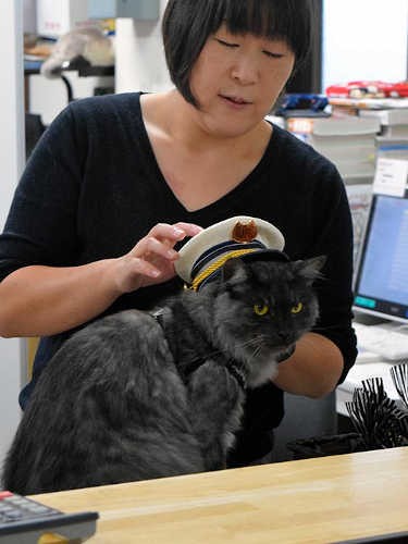 出札窓口で制帽をかぶるしょこらと細谷さん