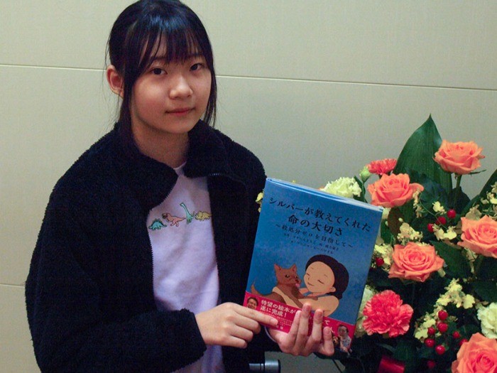 「おとなにも読んでもらえたら」と絵本を手にする愛葉さん