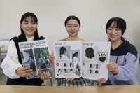 完成したカタログを手に笑顔を見せる学生たち