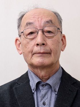 吉田裕さんの顔写真。白い背景で、青系のシャツに黒のジャケットを着用している