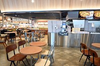 木製家具が並ぶイートインスペースでは、コーヒーとともに、ピザやパン、惣菜などが楽しめます