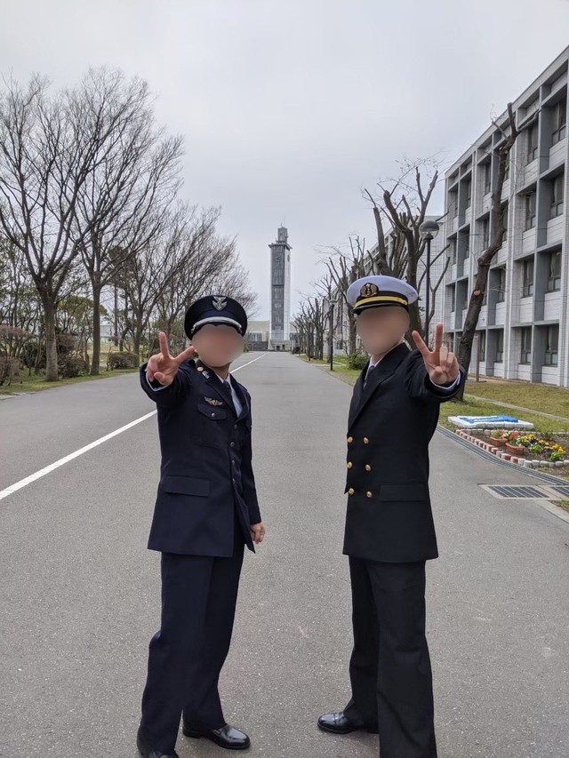 陸海空自衛官の任命式の後のはじめさん（左）。同期と、シンボルの時計台をバックに／はじめさん（@hajime20250823）提供