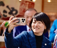 候補者とスマホで自撮りする自民党の鈴木貴子広報本部長＝大阪府吹田市