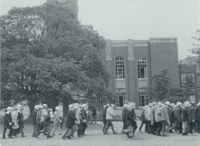 ヘルメットをかぶり、口元にマスクやタオルを付けて歩く学生とみられる集団（京都市左京区・京都大）