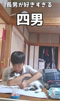 抱きしめながら、宿題をする長男くん（井上えりさん提供、Instagramよりキャプチャ撮影）