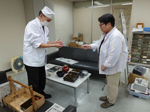 引っ越し準備まっただ中の旧編集局に出前を届ける上田さん（８月２０日）