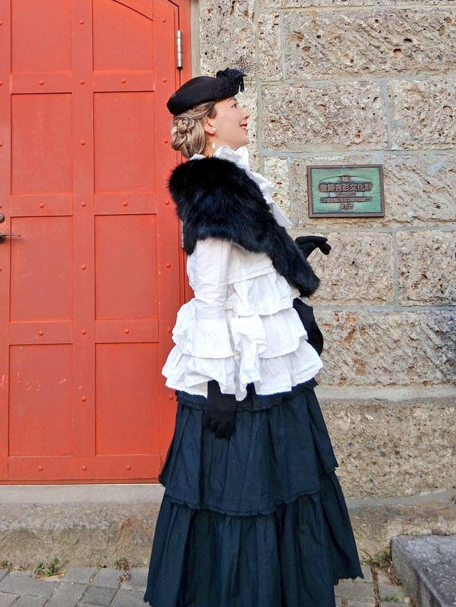 石壁と赤い扉を背に、モノクロのPINK HOUSEコーデでたたずむあすかさ／あすかさん（@asukawwide1225）提供