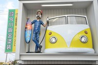 道路を走っていて目に入ると、思わず注視してしまいそうな独創的な看板。すぐ横には社名を書いた通常の看板もある