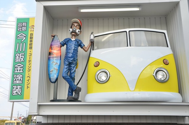 道路を走っていて目に入ると、思わず注視してしまいそうな独創的な看板。すぐ横には社名を書いた通常の看板もある