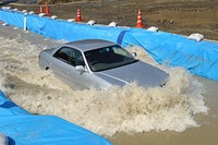 JAFによる冠水路走行の問題点検証テスト（2010年4月実施）。これは水深30cm・時速30kmで走行した時のもの。巻き上げる水の量が多くなり、エンジンルームに多量の水が入ることがわかった（画像提供：JAF）