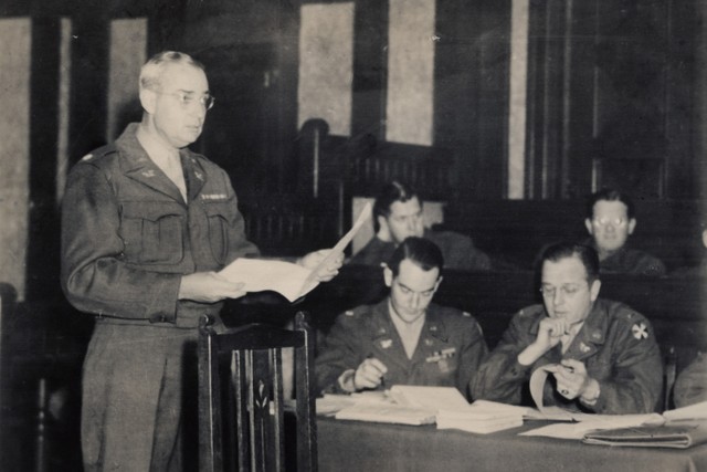 横浜法廷で裁判進行の諸手続きを打ち合わせる弁護人、ジョン・ディッキンソン中佐（左）