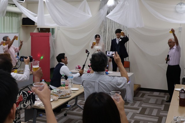 ２人の前途を祝い、披露宴で乾杯する参加者ら（宮津市小田・上宮津地区公民館）