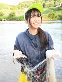 網で捕ったアユを手に笑顔を見せる真庭悠萌さん＝島根県益田市、高津川