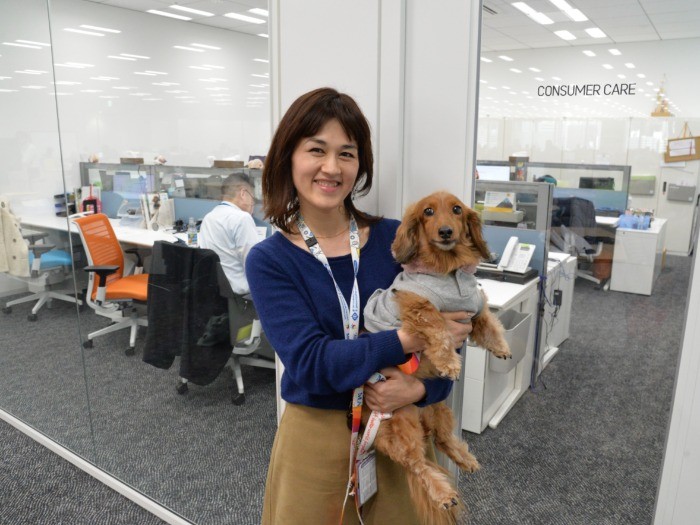 相談室の前で伊万里を抱く根本さん「癒やされます」