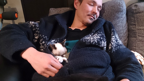 迎えた初日から、学さんの懐でくつろぐスイくん（山田敦子さん提供）