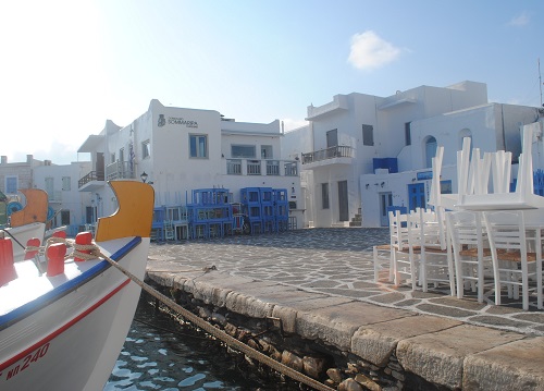 ナウサの朝。よく手入れされた古い漁船と、片づけて積まれたテーブルセット。